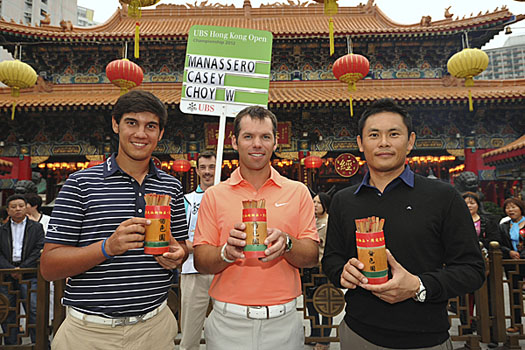 Matteo Manassero (L) and Paul Casey (C) were shown the Chinese fortune sticks by Wilson Choy