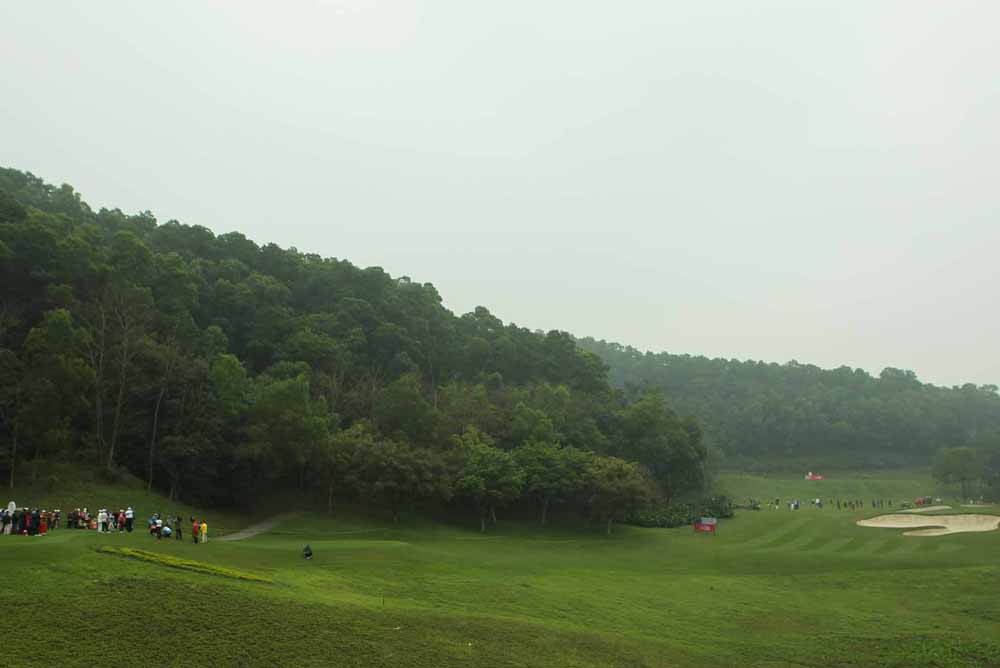 The crowd gathers at the par-3 13th