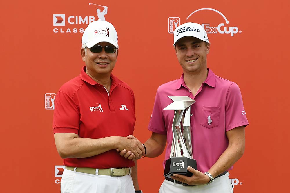 Justin Thomas shakes hands with Malaysia's Prime Minister Najib Razak