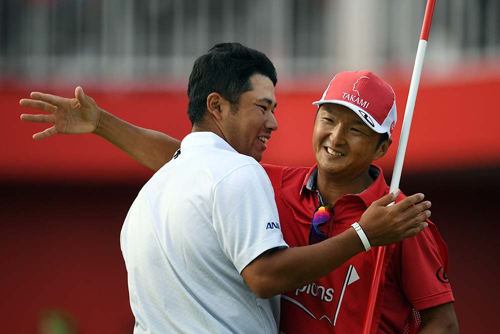 Matsuyama celebrates his victory with his caddy following the final round of 2016 WGC-HSBC Champions