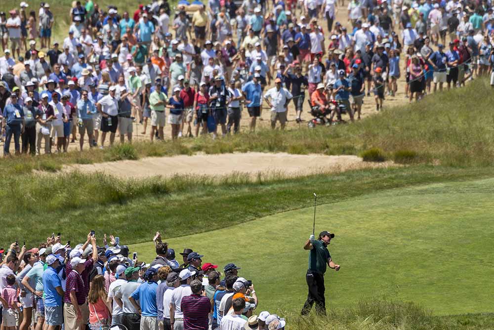 Phil Mickelson watches a shot from the rough on the ninth hole