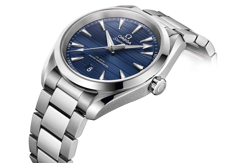 The 38mm model is presented in pure stainless steel with a deep blue dial and rhodium-plated hands and indexes