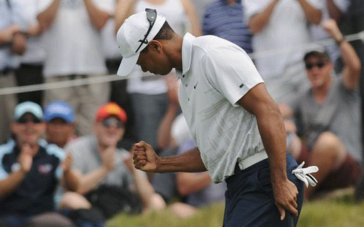 Tiger Woods fist pumps after sinking a a long putt