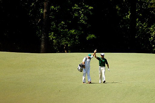 Louis Oosthuizen high-fives his caddy after sinking the fourth albatross in Masters history