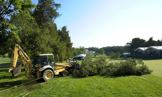 A fallen tree is removed from the 18th fairway