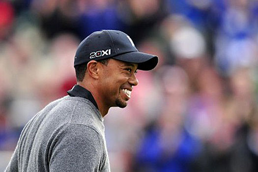 Tiger Woods holes out for birdie from a pot bunker at the 18th