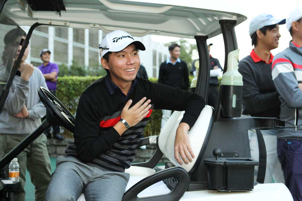 Terrence Ng watches the final group approach the 18th green