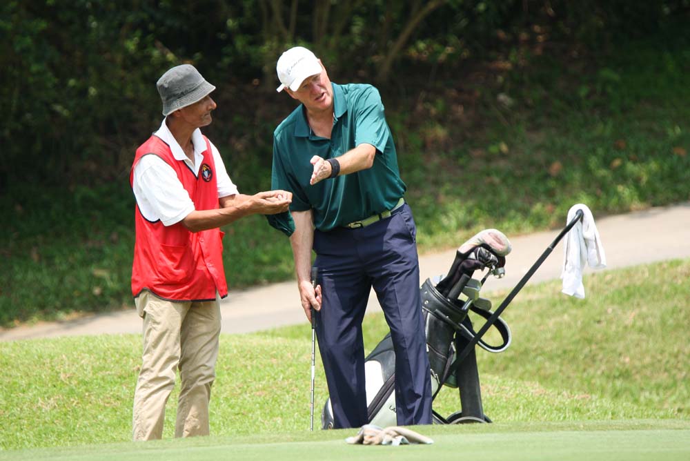 James Barrington checks the green with caddie Ringo